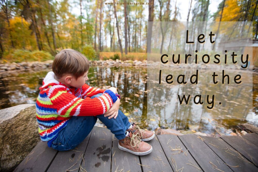 Boy sitting beside a pond observing nature on a fall day